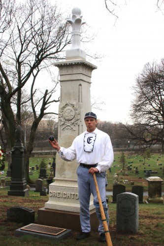 Eric Miklich, holding a lemon-peel baseball in front of the newly-unveiled monument to James Creigton.