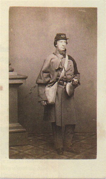 Surgeon Timothy Cheeseman, with a haversack slung over his shoulder, an uncovered canteen (standard in the 7th), a heavy overcoat, and a pistol, ready for a cold-weather march. 