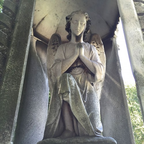 The French Angel prays under a marble canopy.