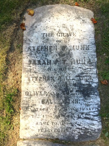 Stephen B. Munn's marble gravestone, circa 1855, lying flat on the grass.