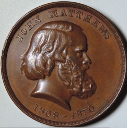 This promotional coin was issued by the John Matthews Company. It shows the face of the company's founder and his life dates. The Green-Wood Historic Fund Collections.