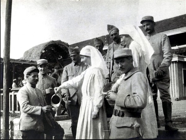 The Cromwell twins with French Army soldiers in Chalons, France. Dorothea is a left, pouring from the pitcher. Glaydsi is at right.