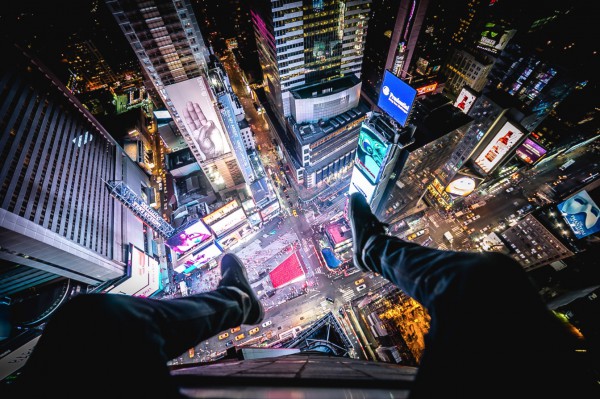 Christopher's signature set-up: his legs in the foreground, with a night scene of New York City below (in this case, high above Times Square).