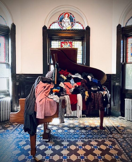 grand piano filled with clothing