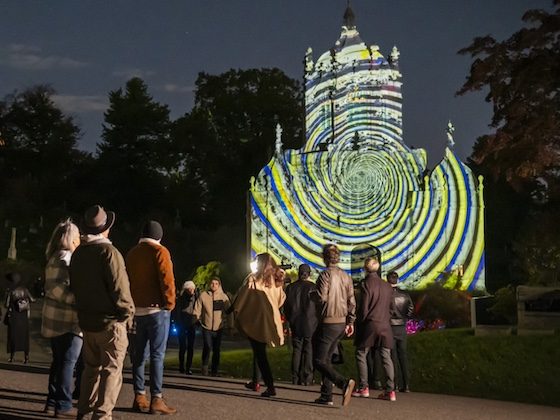 spectators watch projection on historic chapel