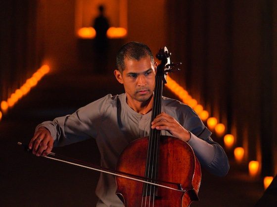 cellist in dim catacombs lighting