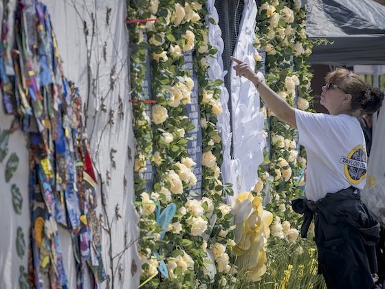 woman points at memorial wall text