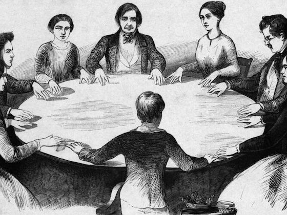 black and white image of everyone touching a tabletop