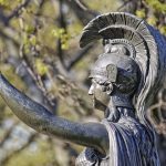 green-wood minerva statue with arm raised