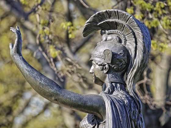 green-wood minerva statue with arm raised