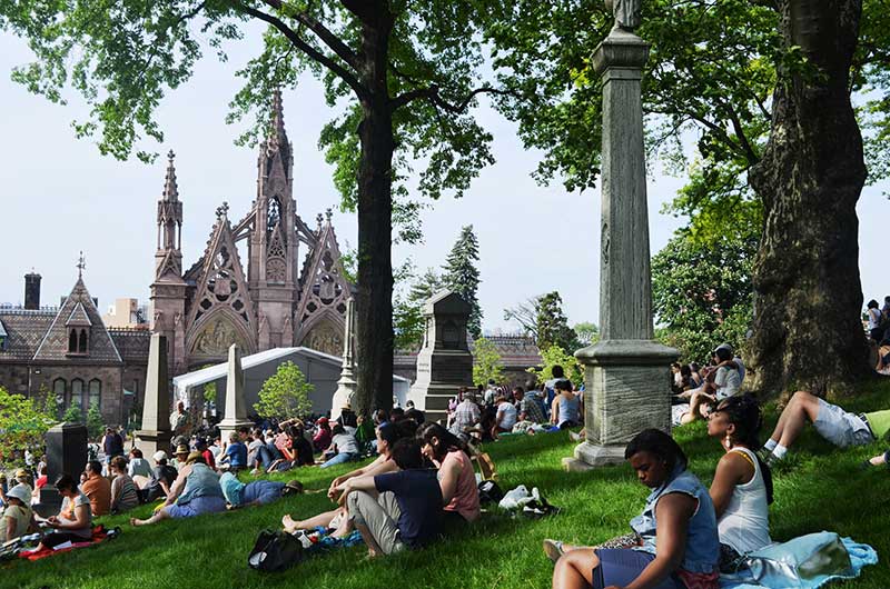 image of people sitting in green-wood cemetery